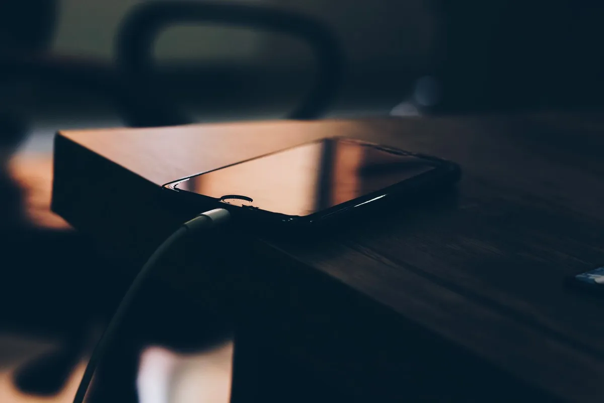 Celular conectado al cargador junto a un tinto en la mañana, la carga rápida pesa más que el 5G en el día a día.
