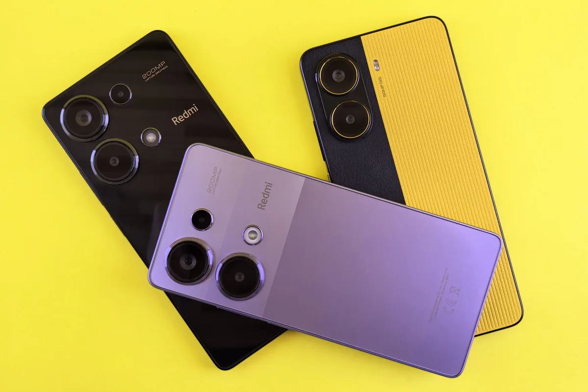 Tres celulares Xiaomi Redmi de distintos colores sobre fondo amarillo.